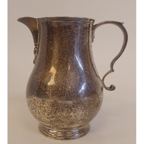 228 - A late Victorian silver sparrow beak, bulbous cream jug with a double C-scrolled handle, on a splaye... 