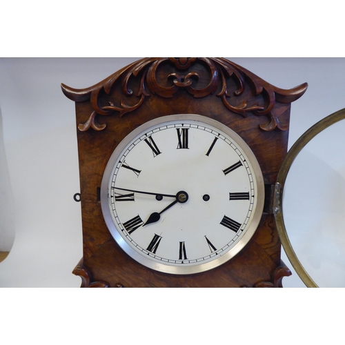 23 - A William IV walnut cased mantel clock with applied, scroll carved ornament, a round arch top, strai... 