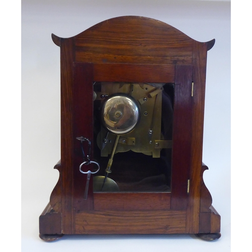 23 - A William IV walnut cased mantel clock with applied, scroll carved ornament, a round arch top, strai... 