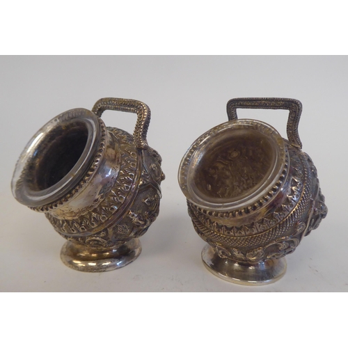 231 - A four piece Anglo-Indian white metal condiments set, cast in vignette panels with religious figures