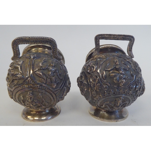 231 - A four piece Anglo-Indian white metal condiments set, cast in vignette panels with religious figures