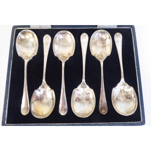 232 - A set of six silver dessert spoons with ribbon tied, applied wire ornament  Mappin & Webb&n... 