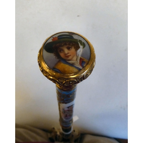 238 - A late 19thC Continental parasol with a painted porcelain handle, depicting a woman playing a musica... 