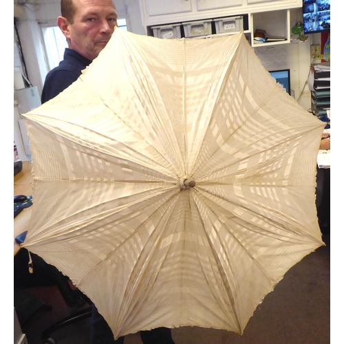 238 - A late 19thC Continental parasol with a painted porcelain handle, depicting a woman playing a musica... 