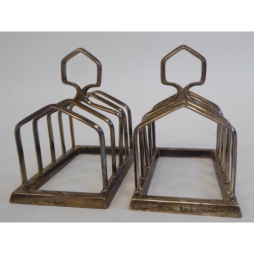 25 - A pair of silver four division wire framed toast racks, on platforms with loop handles  indisti... 