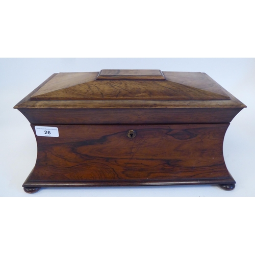 26 - A mid 19thC rosewood tea casket of waisted, sarcophagus form with a lockable hinged lid and opposing... 