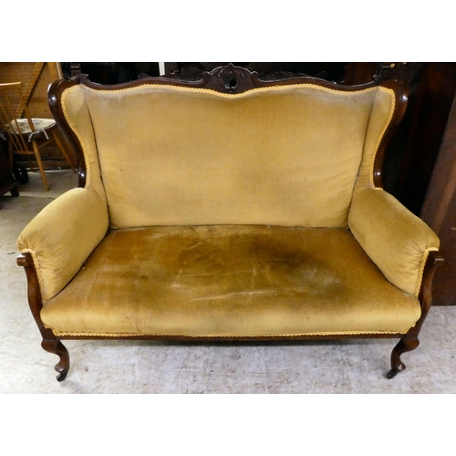 260 - A late Victorian mahogany showwood framed and later fabric upholstered two person settee, raised on ... 