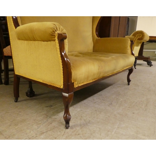 260 - A late Victorian mahogany showwood framed and later fabric upholstered two person settee, raised on ... 