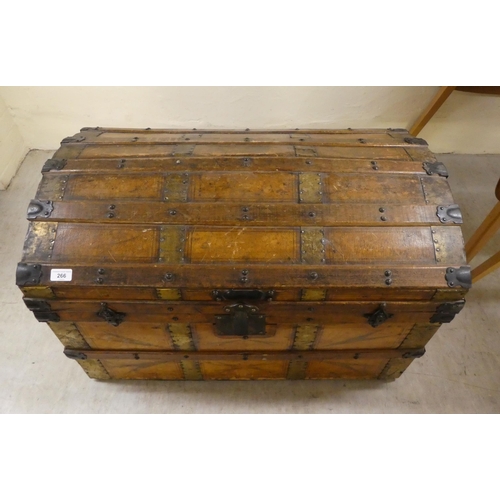 266 - An early 20thC brass and oak bound trunk with straight sides and a hinged, domed lid, on a plinth&nb... 