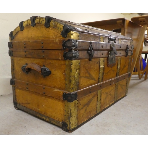 266 - An early 20thC brass and oak bound trunk with straight sides and a hinged, domed lid, on a plinth&nb... 