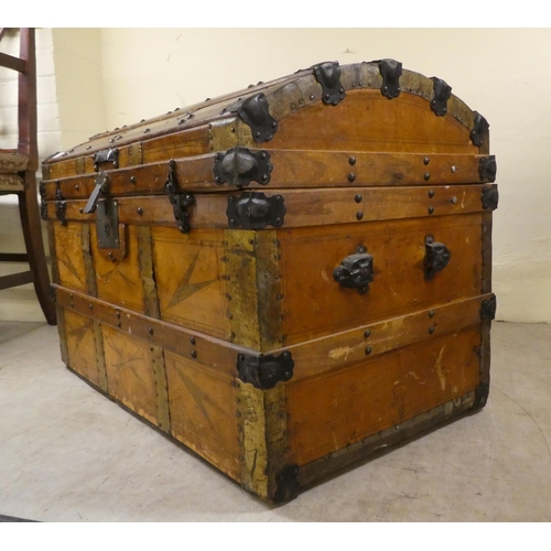 266 - An early 20thC brass and oak bound trunk with straight sides and a hinged, domed lid, on a plinth&nb... 