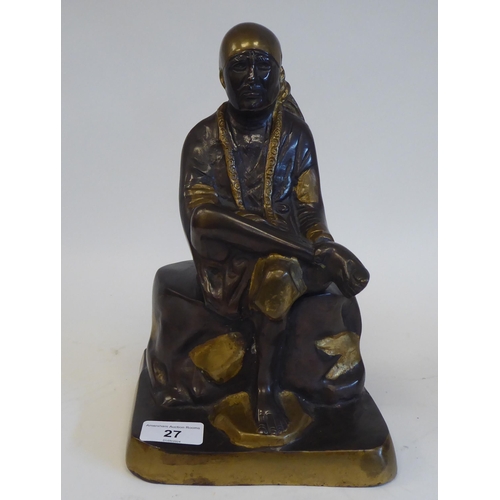 27 - A cast, patinated and part gilded bronze Asian figure, wearing traditional costume and seated on a r... 