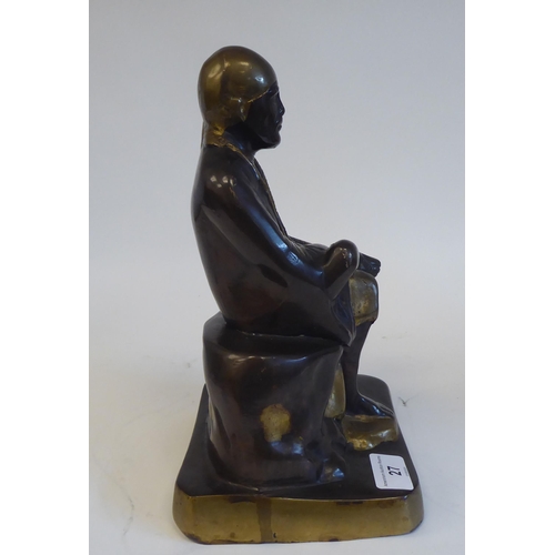 27 - A cast, patinated and part gilded bronze Asian figure, wearing traditional costume and seated on a r... 