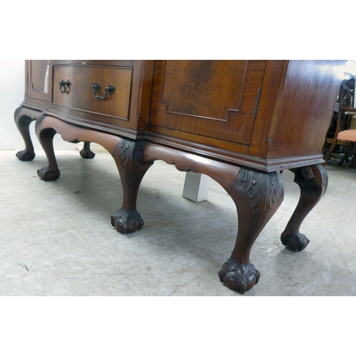 270 - A 1930s mahogany breakfront, bow fronted sideboard with a central bank of three drawers, flanked by ... 