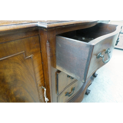 270 - A 1930s mahogany breakfront, bow fronted sideboard with a central bank of three drawers, flanked by ... 