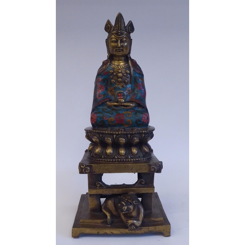 28 - An Asian cast brass and cloisonné Buddhist figure, seated cross-legged on a cushion plinth, g... 