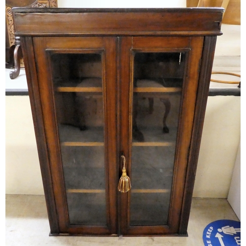 285 - An early 20thC mahogany bookcase with two glazed doors, on a plinth  45