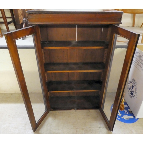 285 - An early 20thC mahogany bookcase with two glazed doors, on a plinth  45