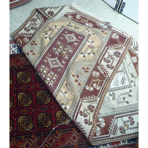 297 - Three dissimilar rugs: to include a Turkish example with repeating box design motifs, on a multi-col... 