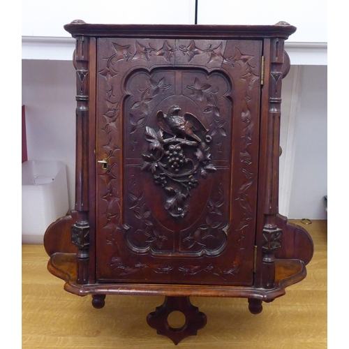 37 - A late 19thC walnut hanging cupboard, the full-height, lockable door enclosed by a panelled door, fe... 