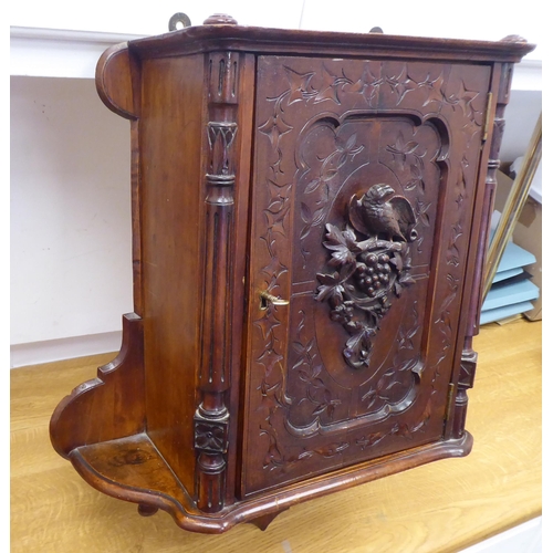 37 - A late 19thC walnut hanging cupboard, the full-height, lockable door enclosed by a panelled door, fe... 