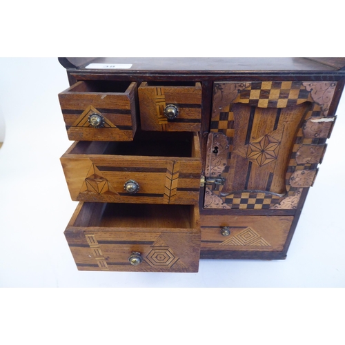 38 - An early 20thC Japanese table-top collector's cabinet, finished in a variety of exotic woods, incorp... 