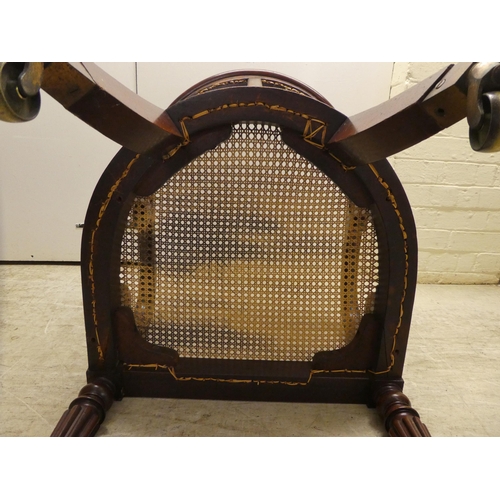 39 - A William IV mahogany framed bergere, the tub style back with a scrolled crest, a woven split cane b... 