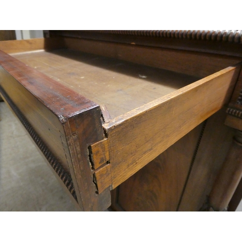 63 - A William IV mahogany chiffonier with a raised back, incorporating a shelf over a frieze drawer and ... 