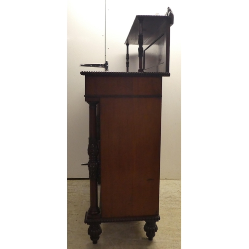 63 - A William IV mahogany chiffonier with a raised back, incorporating a shelf over a frieze drawer and ... 