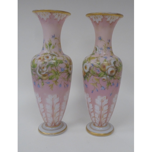 66 - A pair of late 19thC milk glass, gilded and overpainted baluster shape vases with narrow necks and f... 