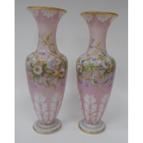 66 - A pair of late 19thC milk glass, gilded and overpainted baluster shape vases with narrow necks and f... 