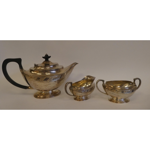 7 - A three piece silver tea set of Aladdin's lamp design, comprising a teapot with bright-cut engraved ... 