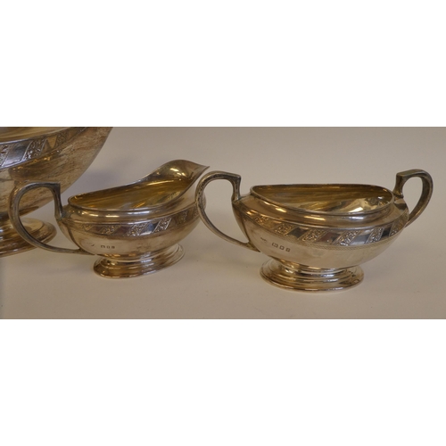 7 - A three piece silver tea set of Aladdin's lamp design, comprising a teapot with bright-cut engraved ... 