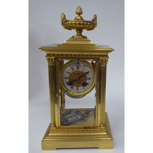 71 - An early 20thC gilt metal cased, four glass mantel clock with bevelled panels, surmounted by a twin ... 