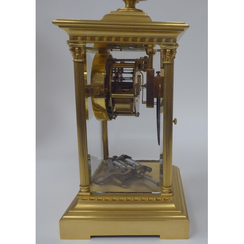 71 - An early 20thC gilt metal cased, four glass mantel clock with bevelled panels, surmounted by a twin ... 