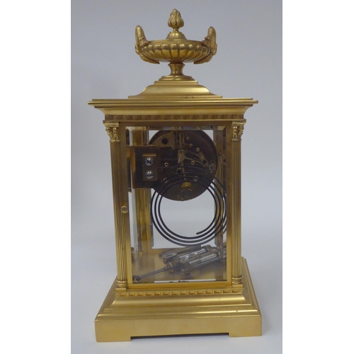 71 - An early 20thC gilt metal cased, four glass mantel clock with bevelled panels, surmounted by a twin ... 