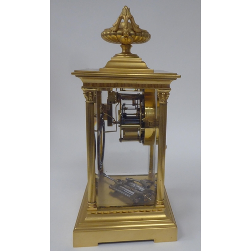 71 - An early 20thC gilt metal cased, four glass mantel clock with bevelled panels, surmounted by a twin ... 