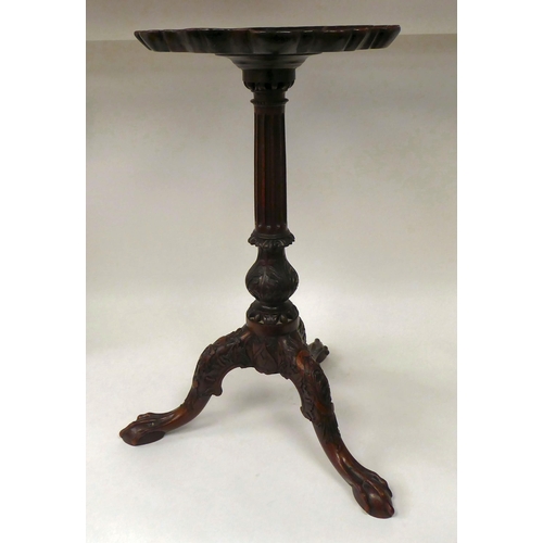 81 - A 19thC mahogany pedestal wine table with a piecrust border, over a fluted column and a profusely ca... 