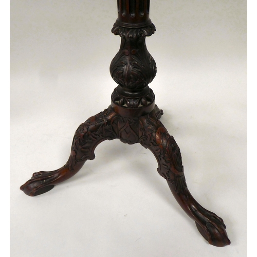 81 - A 19thC mahogany pedestal wine table with a piecrust border, over a fluted column and a profusely ca... 