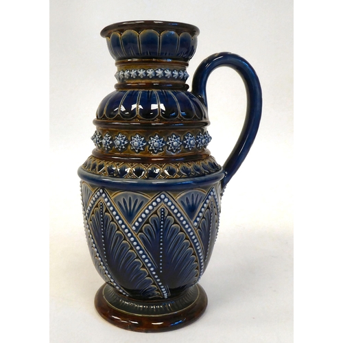 88 - A Doulton Lambeth blue and brown stoneware pedestal jug with a loop handle and cup lip, decorated in... 