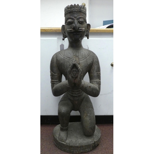 92 - An antique carved wooden figure, a Hindu god, on a circular plinth  34