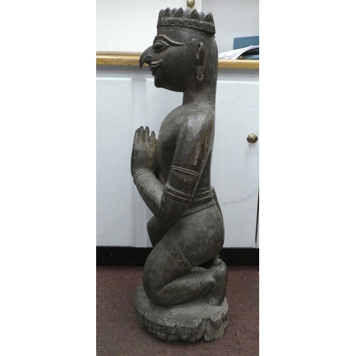 92 - An antique carved wooden figure, a Hindu god, on a circular plinth  34