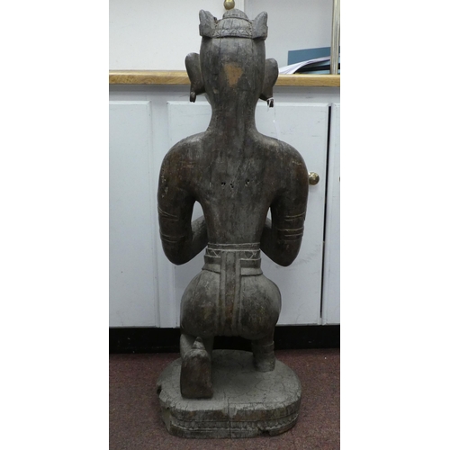 92 - An antique carved wooden figure, a Hindu god, on a circular plinth  34