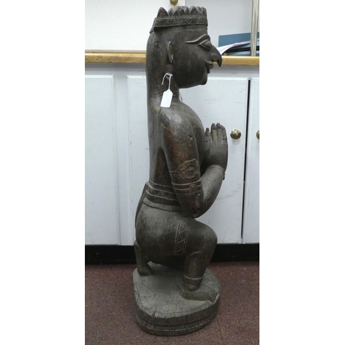 92 - An antique carved wooden figure, a Hindu god, on a circular plinth  34