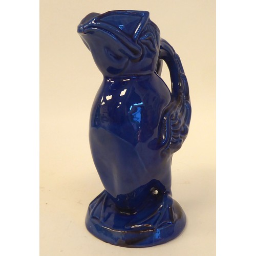 78 - A CH Brannam Barumware blue glazed pottery jug, fashioned as a grotesque puffin  bears an impressed ... 