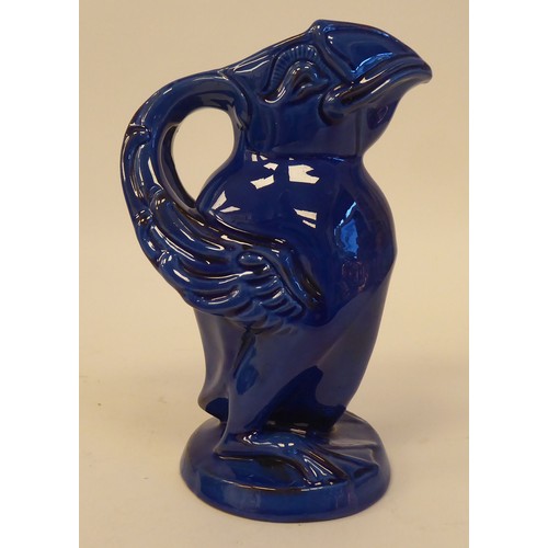 78 - A CH Brannam Barumware blue glazed pottery jug, fashioned as a grotesque puffin  bears an impressed ... 