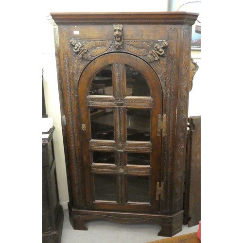 15 - A 19thC and later oak, standing corner cupboard with carved ornament, the full-height, multi-glazed ... 