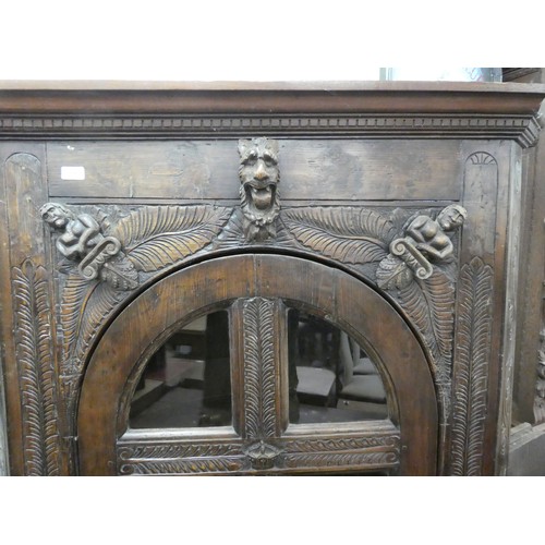 15 - A 19thC and later oak, standing corner cupboard with carved ornament, the full-height, multi-glazed ... 