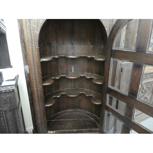 15 - A 19thC and later oak, standing corner cupboard with carved ornament, the full-height, multi-glazed ... 