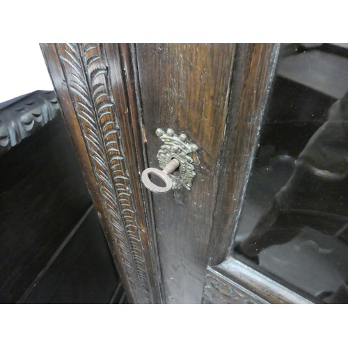 15 - A 19thC and later oak, standing corner cupboard with carved ornament, the full-height, multi-glazed ... 